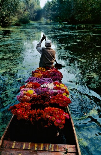 Flower Seller, Dal Lake, Srinagar, Kashmir, 1996 National Geographic, September 1999, Kashmir: Trapped in Conflict "Each morning for two weeks during his 1996 visit to Lake Dal in Kashmir, McCurry travelled with the flower sellers. He had established a ritual for the morning hours, when the sun was at its best. Shortly after dawn, he would begin the day in the market; then he would ride with the boatmen. He knew these were the places for strong pictures. He also knew he needed to work for his pictures, to look and to wait for the right light and action to come together. And then, that morning, from a boat filled with flowers, he caught the boatman's hand in the reflected light of the V of the trees on Lake Dal." - Phaidon 55 Magnum Photos, NYC5901, MCS1999005 K017 Phaidon, 55, South Southeast, Iconic Images, final book_iconic, milan frame, final print_poster, iconic photographs A flower seller paddles through Dal Lake's quiet waters. Few observers expect diplomacy to restore equal serenity to his homeland. Buffeted from within and without by waves of seemingly intractable strife, Kashmir faces a stormy future. Good pictures take time and work. When visiting Lake Dal in 1996, McCurry travelled with the local flower sellers as they journeyed down the river. For two weeks he would ride with the merchants during the morning. On this day the vibrant flowers and boatman, arm raised in mid-paddle, combine with the morning light to create the perfect composition.